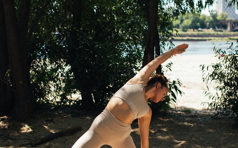 A person in a fluid motion yoga pose against a clean background.