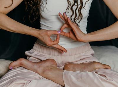 Close-up on hands in a meditative yoga gesture.